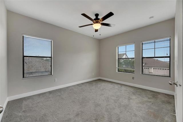 carpeted spare room featuring ceiling fan