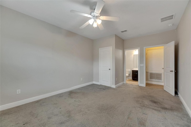 unfurnished bedroom with light carpet, connected bathroom, and ceiling fan