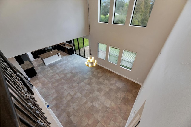 unfurnished living room featuring a chandelier and a high ceiling