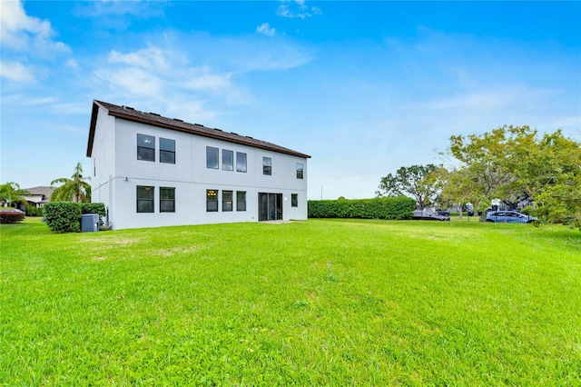 back of property featuring a lawn and central AC