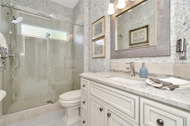 bathroom with vanity, a shower with shower door, and toilet