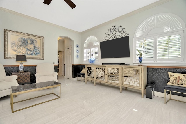 living room with a wealth of natural light, crown molding, and ceiling fan