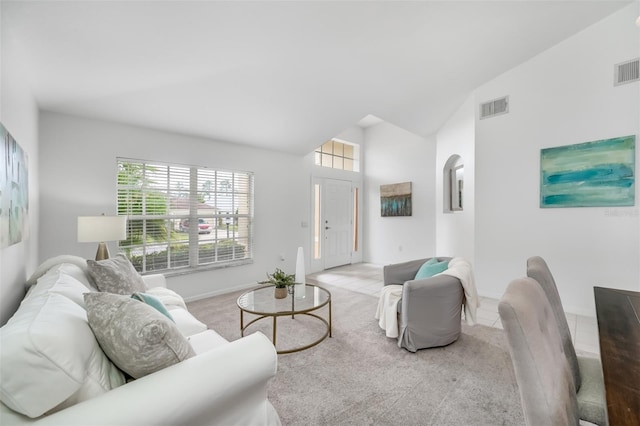 living room with light carpet and high vaulted ceiling