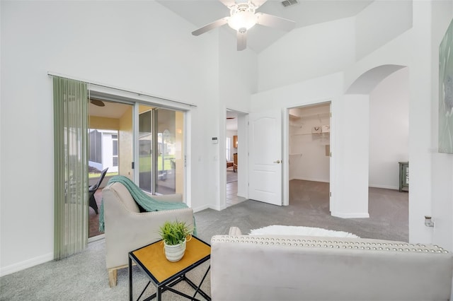 carpeted living room featuring ceiling fan and high vaulted ceiling