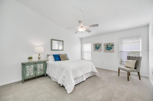 bedroom with ceiling fan, light colored carpet, and vaulted ceiling