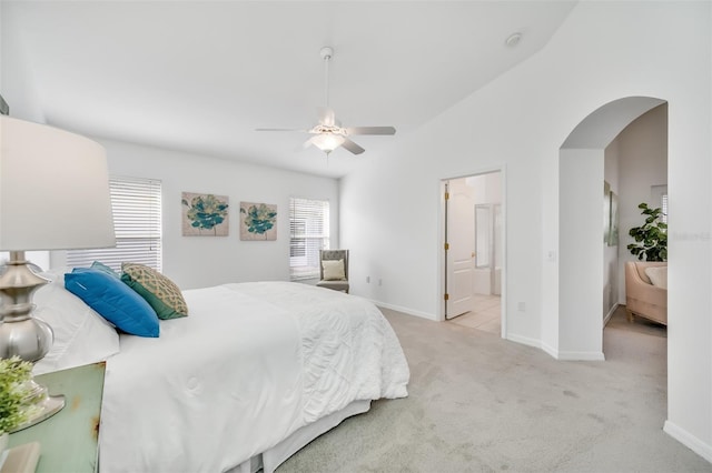 carpeted bedroom with connected bathroom, vaulted ceiling, and ceiling fan