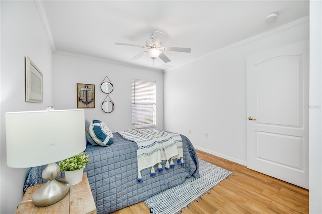 bedroom featuring hardwood / wood-style floors, ornamental molding, and ceiling fan