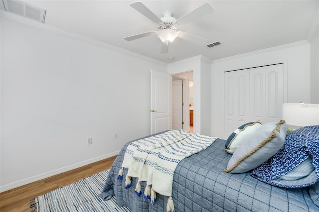 bedroom featuring hardwood / wood-style floors, crown molding, a closet, and ceiling fan