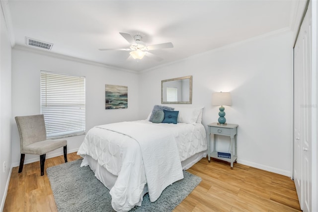 bedroom with crown molding, wood-type flooring, and a closet