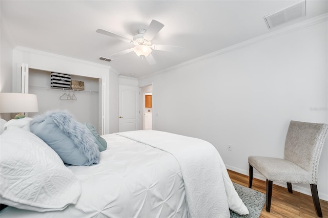 bedroom with hardwood / wood-style floors, crown molding, a closet, and ceiling fan