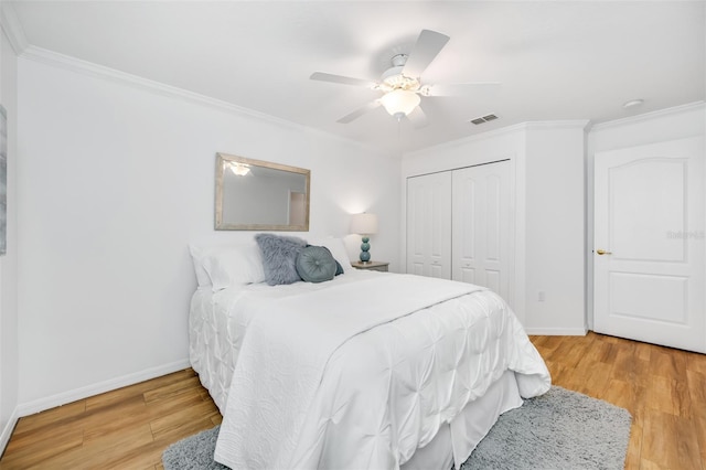 bedroom with hardwood / wood-style floors, crown molding, and a closet