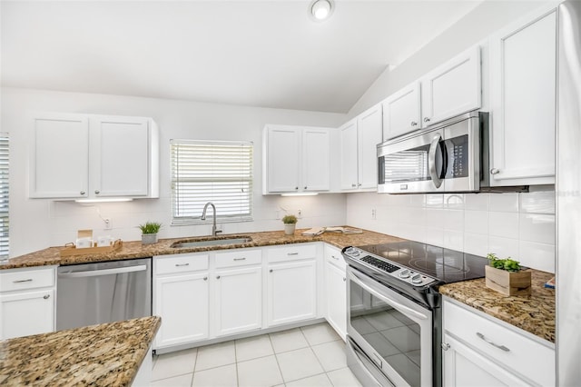 kitchen featuring white cabinetry, appliances with stainless steel finishes, and dark stone countertops