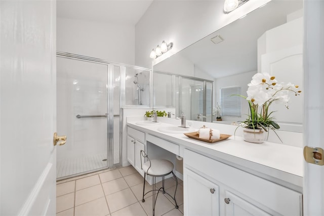 bathroom featuring walk in shower, vanity, vaulted ceiling, and tile patterned flooring