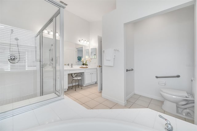 bathroom featuring tile patterned flooring, vanity, a shower with door, and toilet