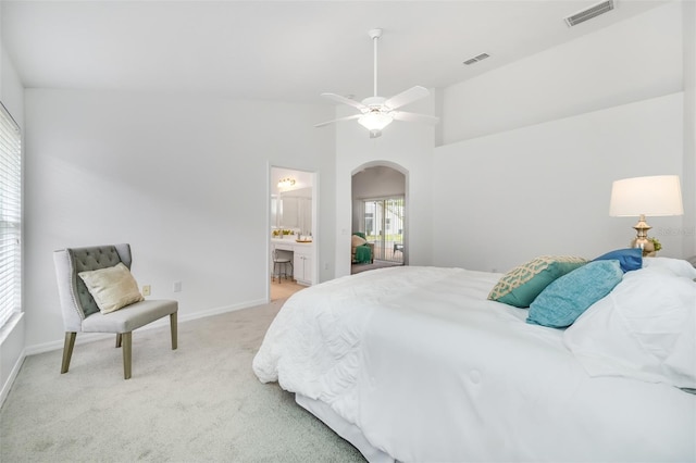 carpeted bedroom featuring ceiling fan, ensuite bathroom, and vaulted ceiling