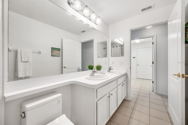 bathroom featuring vanity, toilet, and tile patterned flooring