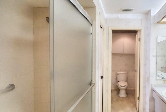 bathroom featuring an enclosed shower, vanity, and toilet