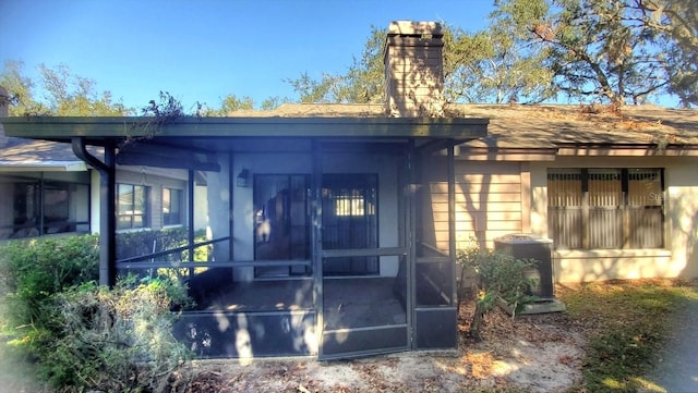 back of property with a sunroom and central AC unit