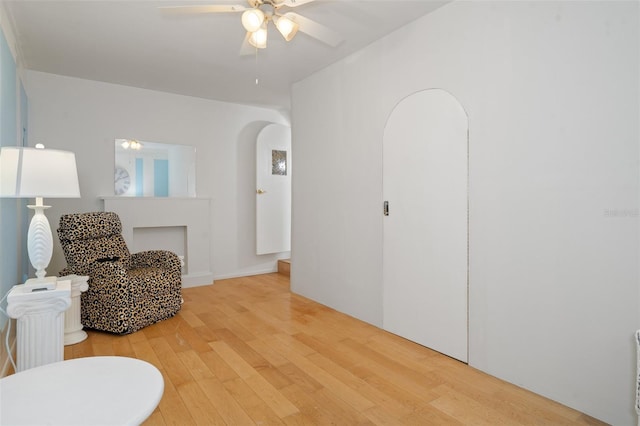 sitting room with wood-type flooring and ceiling fan