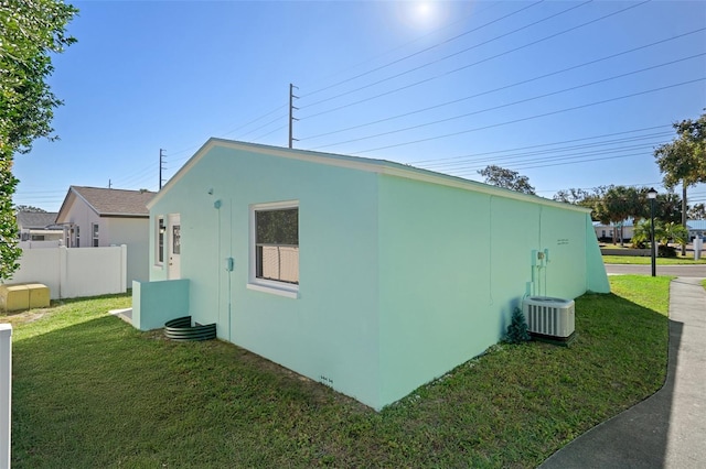 view of property exterior with a yard and central AC