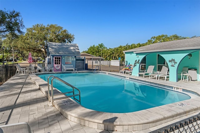 view of swimming pool with a patio area and an outbuilding