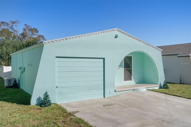 garage with central AC unit and a lawn