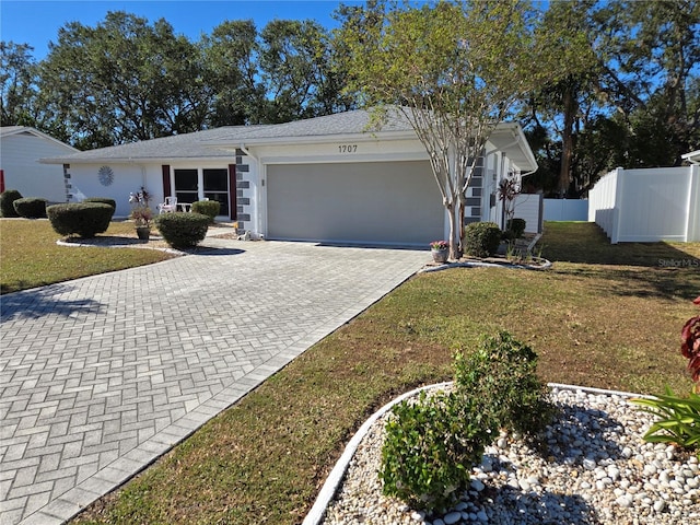 ranch-style house featuring a garage and a front lawn