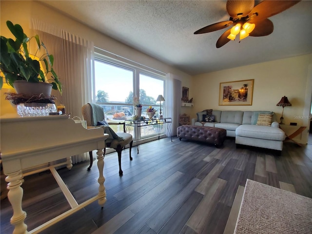 living room with ceiling fan, dark wood-type flooring, and a textured ceiling