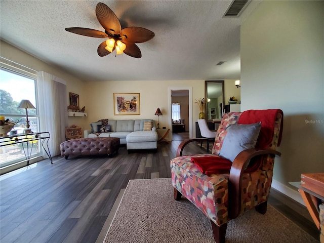 living room featuring ceiling fan, a textured ceiling, and hardwood / wood-style flooring