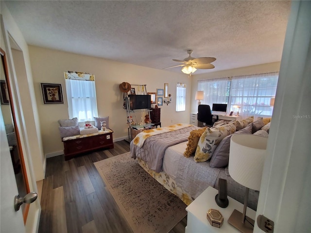 bedroom with a textured ceiling, ceiling fan, and dark hardwood / wood-style floors