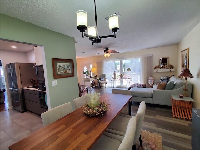 dining area with ceiling fan, a textured ceiling, and light hardwood / wood-style flooring