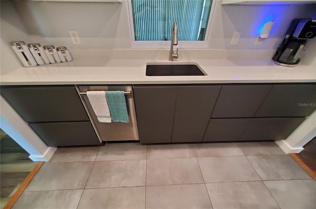 kitchen with light tile patterned floors, stainless steel dishwasher, and sink