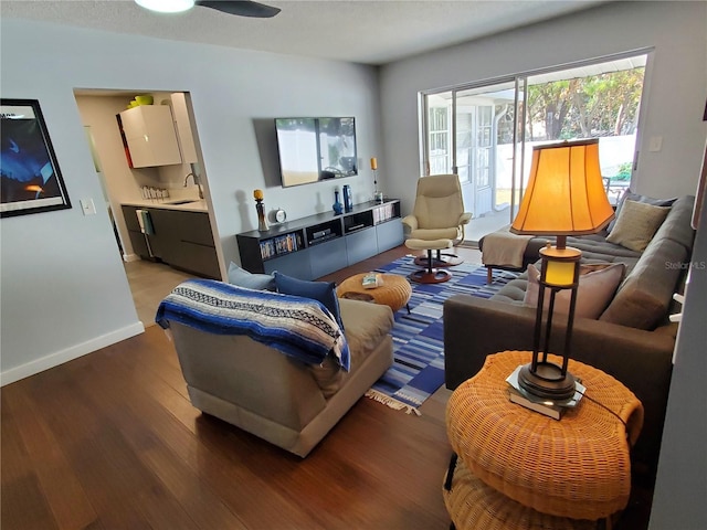 living room featuring ceiling fan, sink, and wood-type flooring