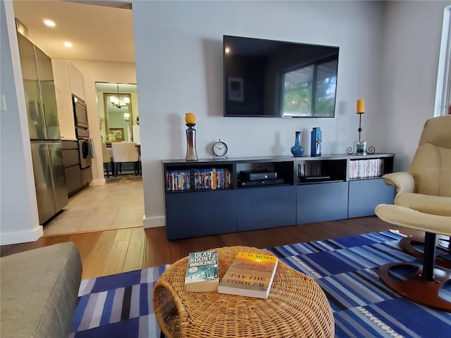 living room featuring light wood-type flooring and an inviting chandelier