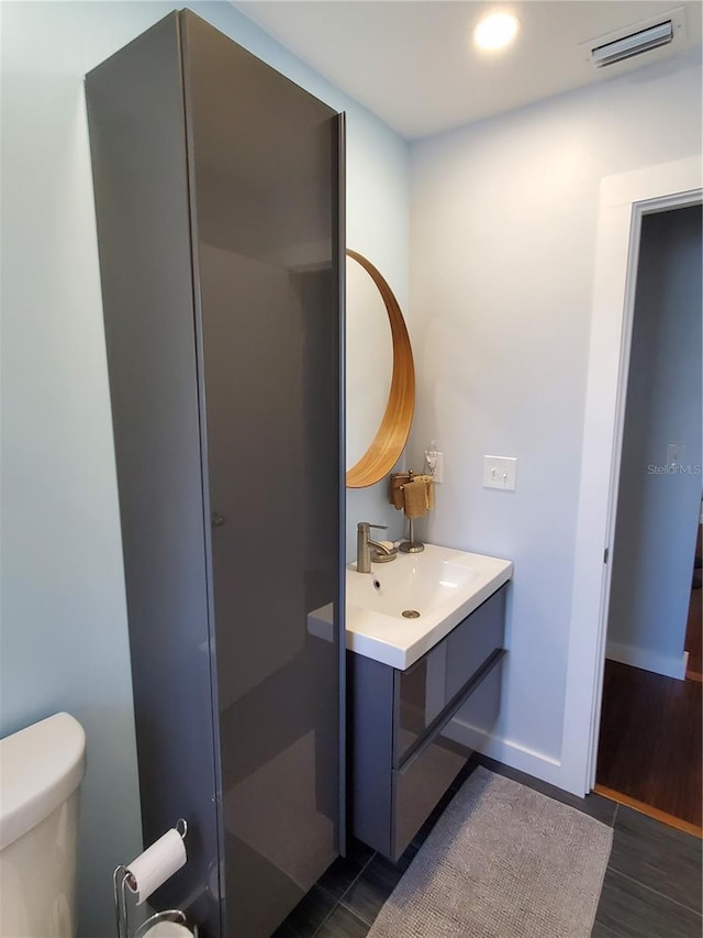 bathroom featuring vanity, toilet, and wood-type flooring