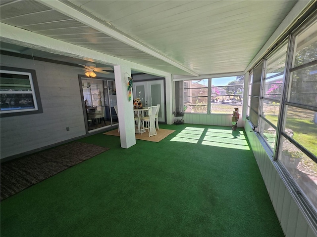 unfurnished sunroom featuring beam ceiling and ceiling fan