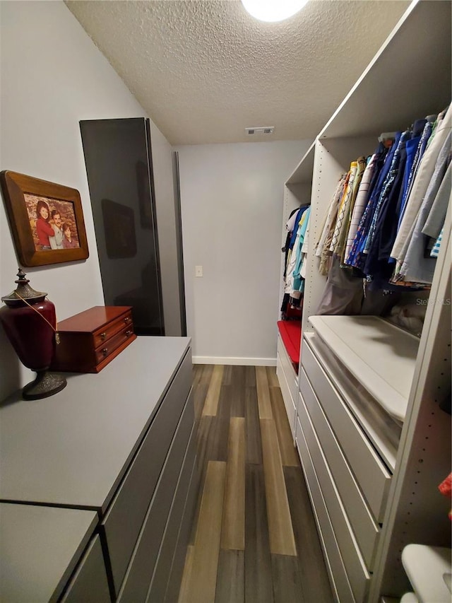 spacious closet featuring dark hardwood / wood-style flooring