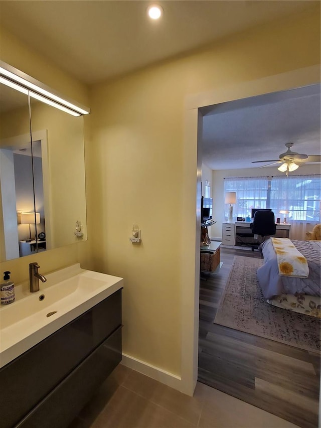 bathroom with ceiling fan, vanity, and wood-type flooring