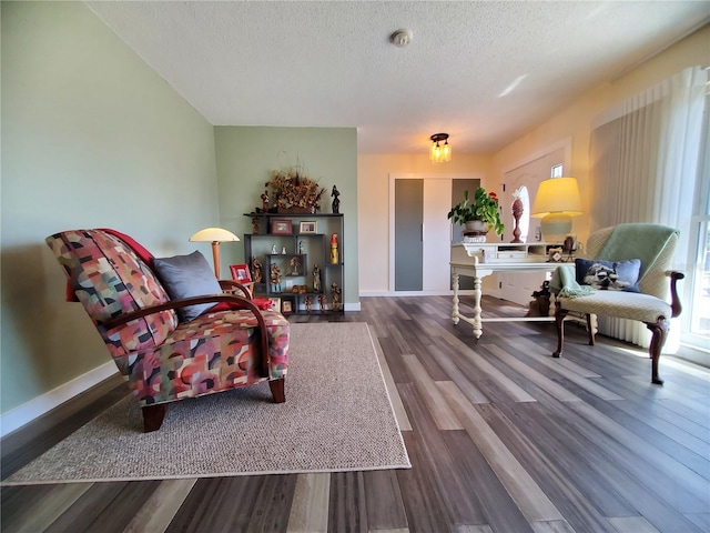 sitting room with hardwood / wood-style floors and a textured ceiling