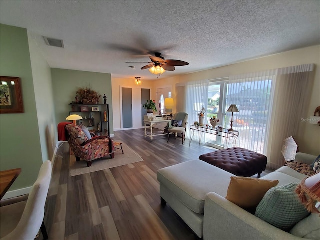 living room featuring wood-type flooring, a textured ceiling, and ceiling fan