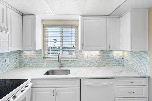 kitchen featuring white cabinetry, white appliances, sink, and tasteful backsplash