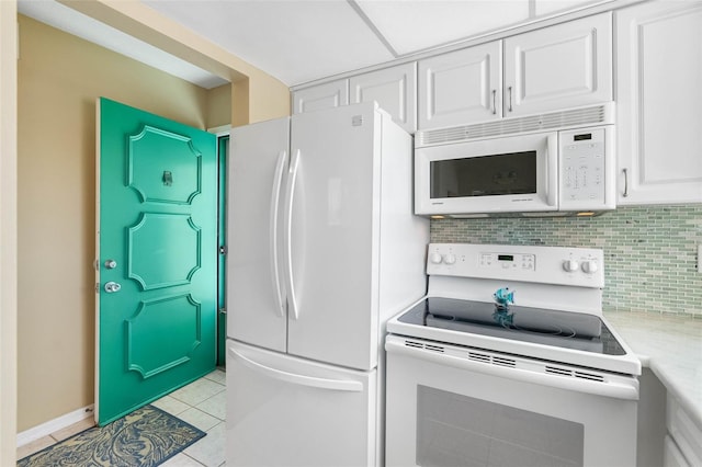 kitchen with backsplash, white cabinetry, light tile patterned floors, and white appliances