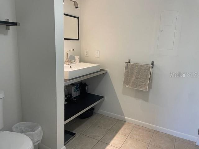 bathroom with tile patterned flooring, electric panel, toilet, and sink