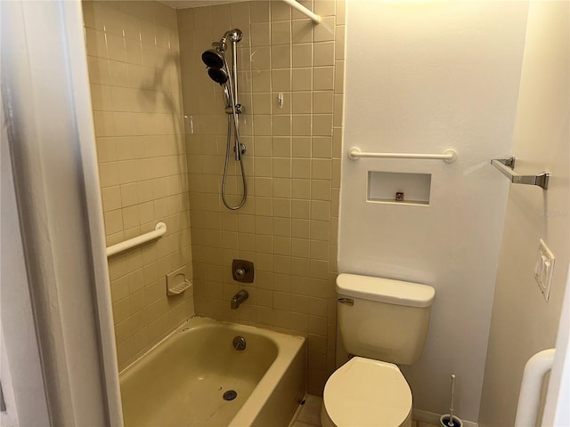 bathroom with toilet and tiled shower / bath