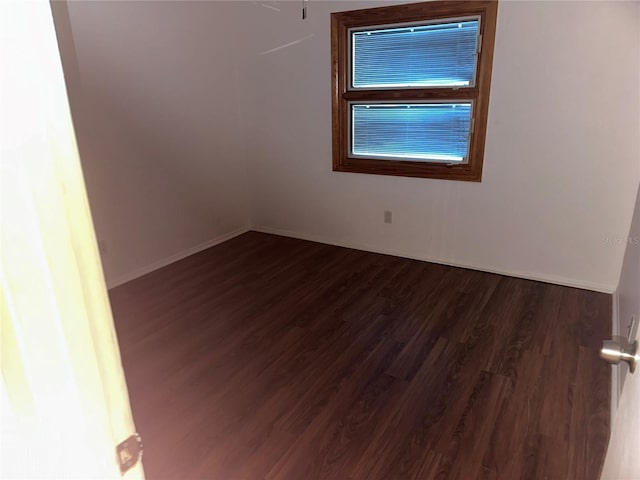 empty room with dark hardwood / wood-style flooring