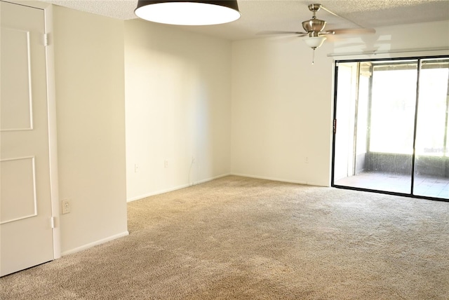 unfurnished room featuring a textured ceiling, ceiling fan, and light colored carpet