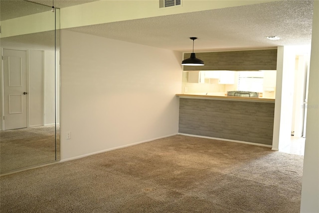 carpeted spare room featuring a textured ceiling