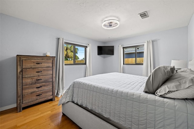 bedroom with wood-type flooring and a textured ceiling