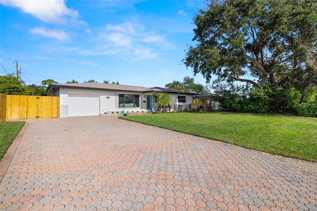 single story home featuring a garage and a front yard