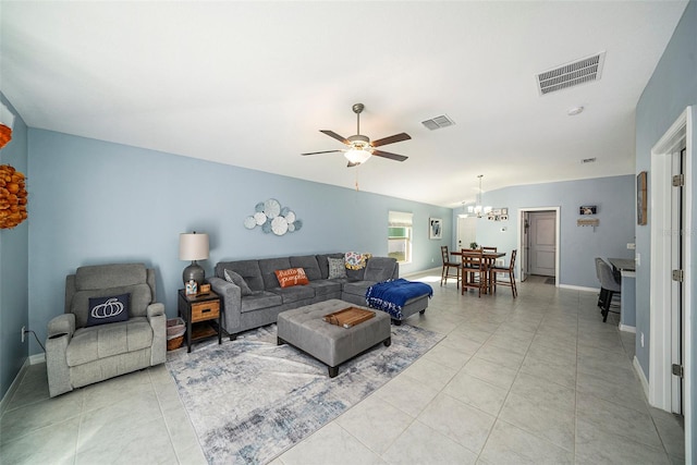 living room featuring ceiling fan with notable chandelier, vaulted ceiling, and light tile patterned flooring